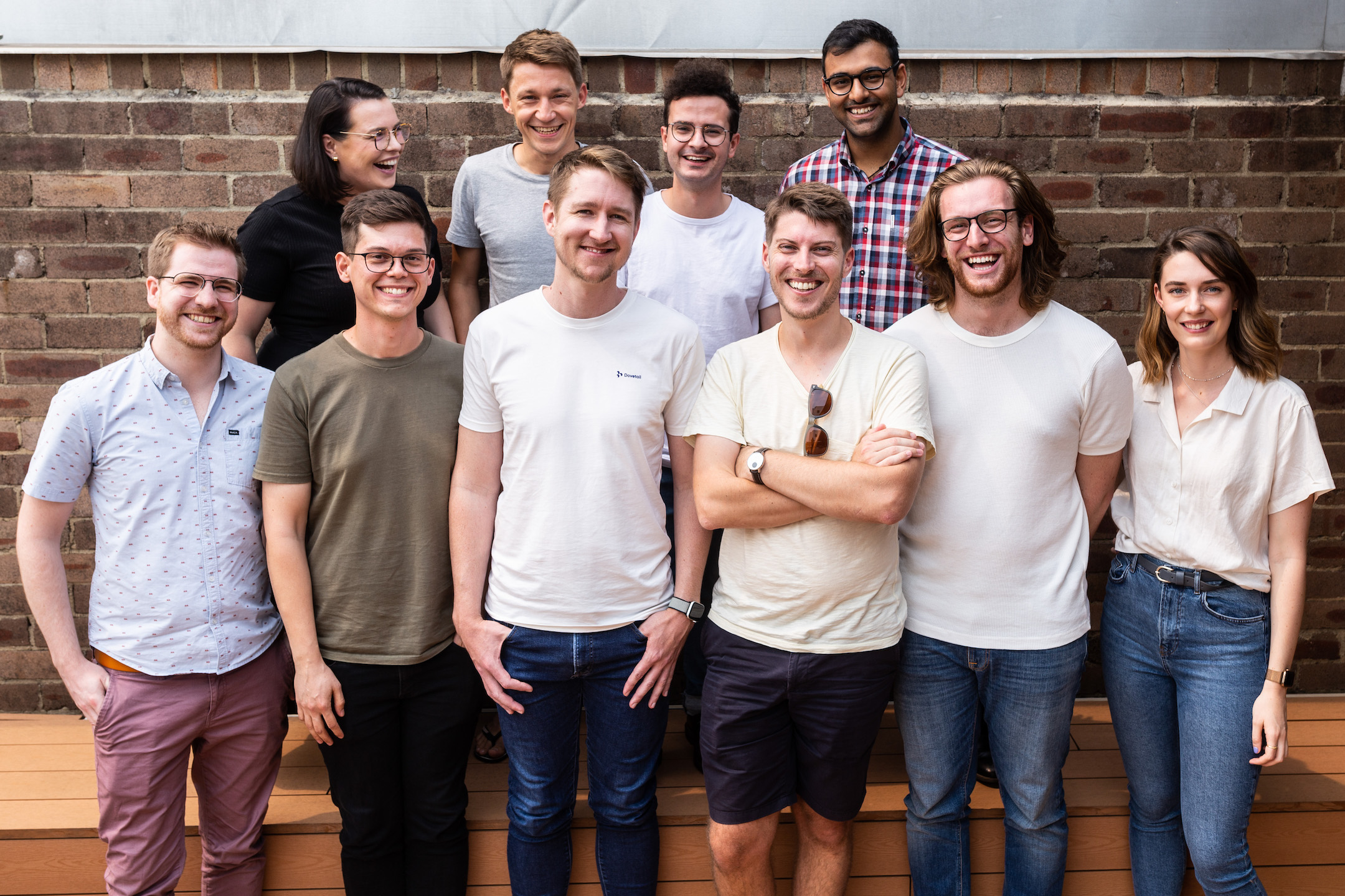The Dovetail team standing against a brick wall.